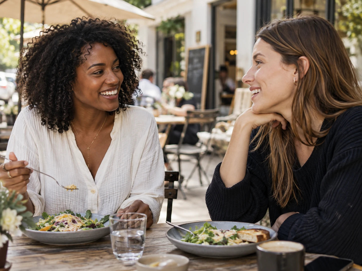 Two friends sharing a relaxed meal at an outdoor café